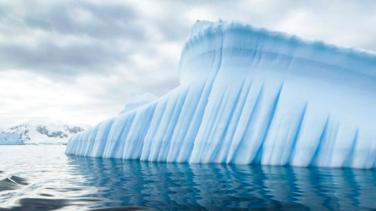 Recursos naturales de la Antártida 81 Iceberg azul junto a montañas en la Antártida