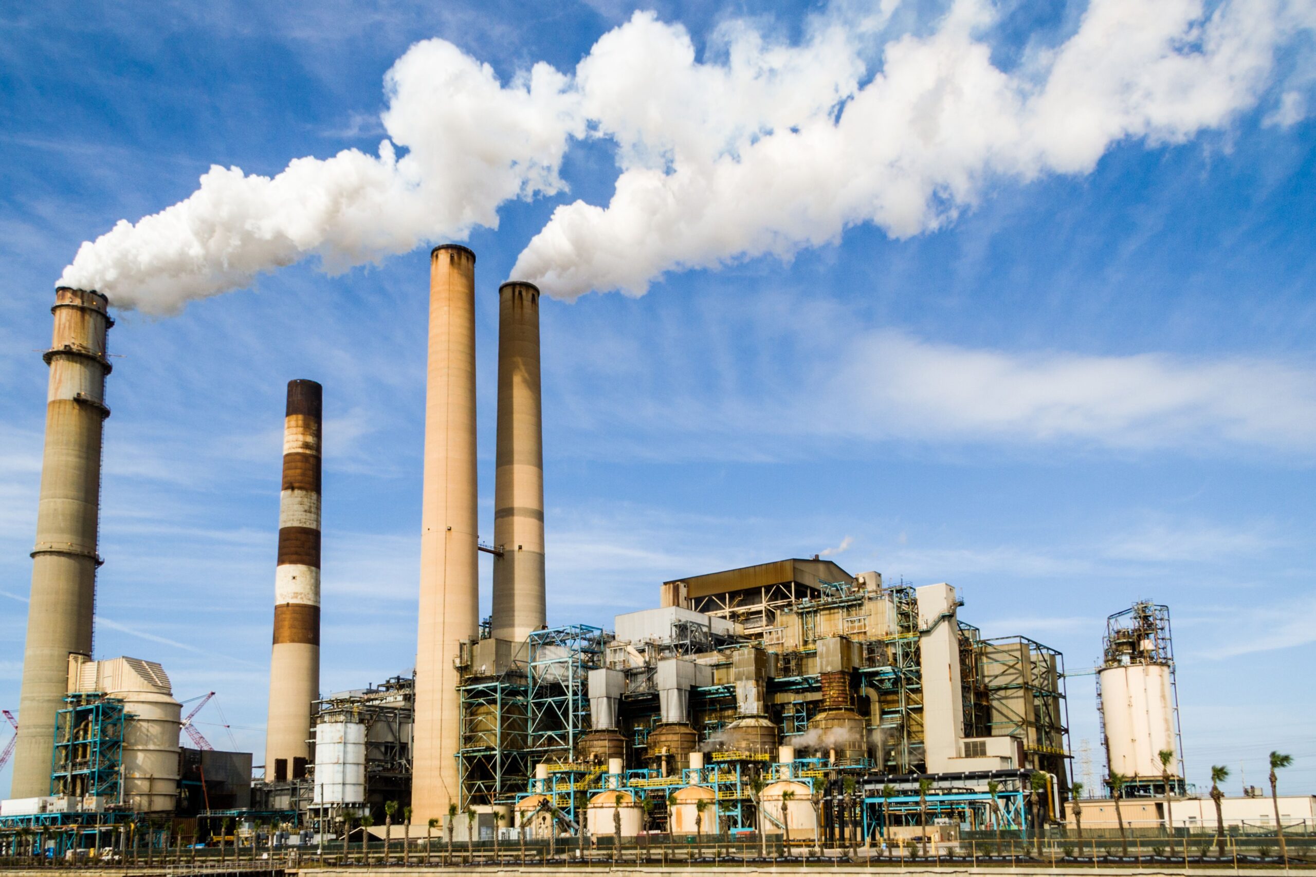 Central térmica con chimeneas emitiendo humo al cielo
