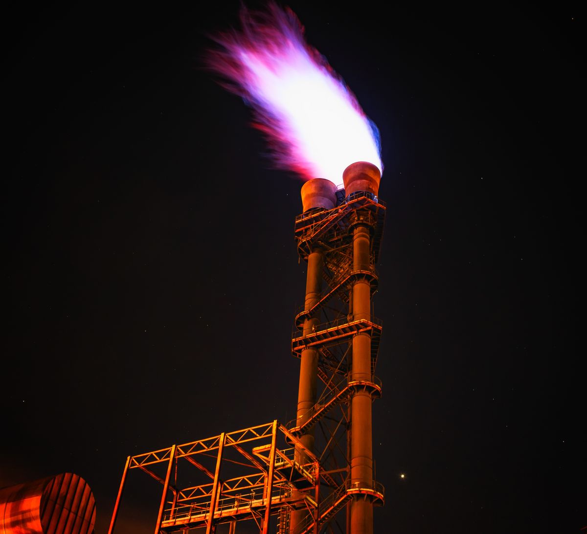 Gas natural: qué es, cómo se forma y usos 6 Antorcha de quema de gas en instalación industrial de noche