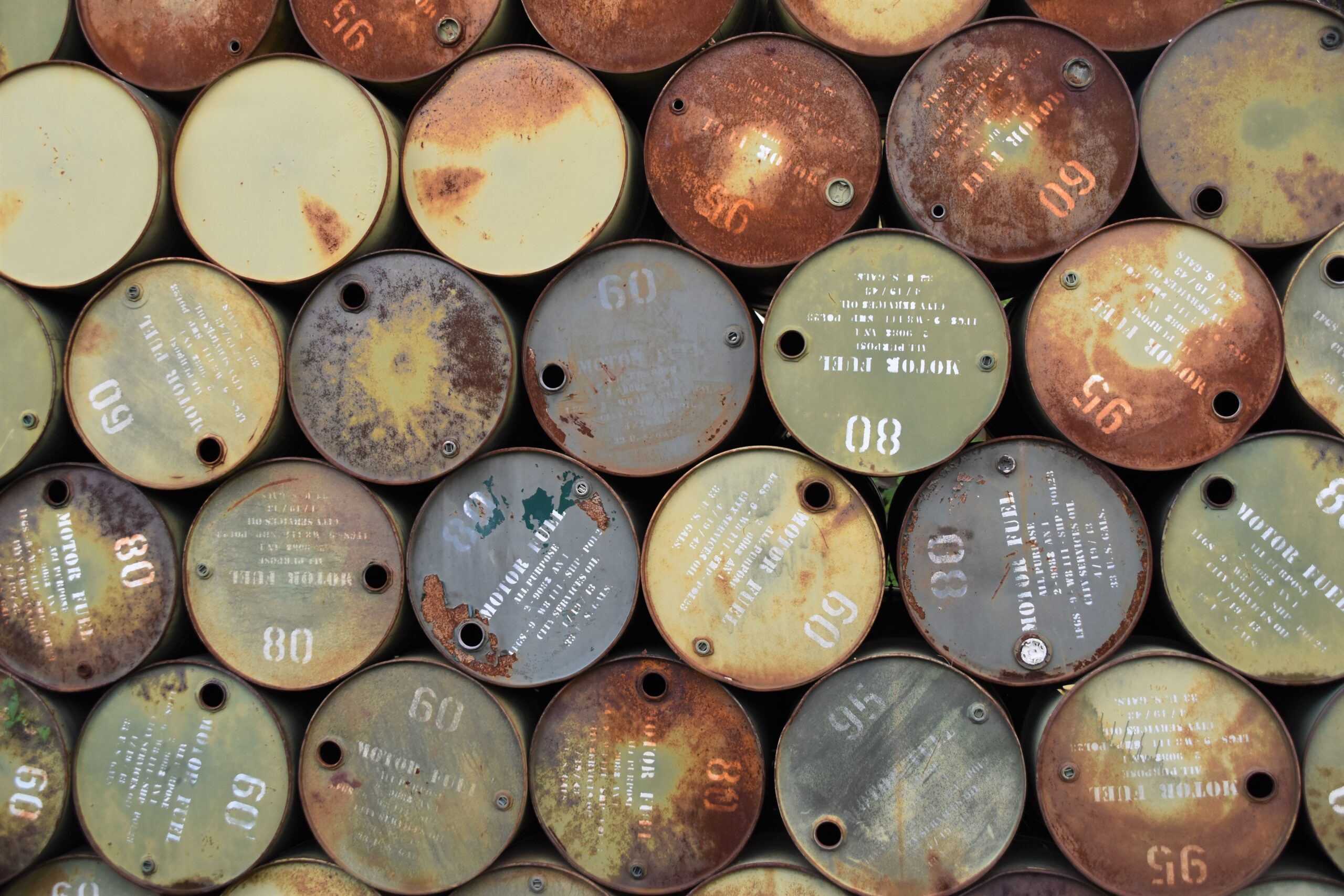 Barriles de petróleo oxidados apilados al aire libre