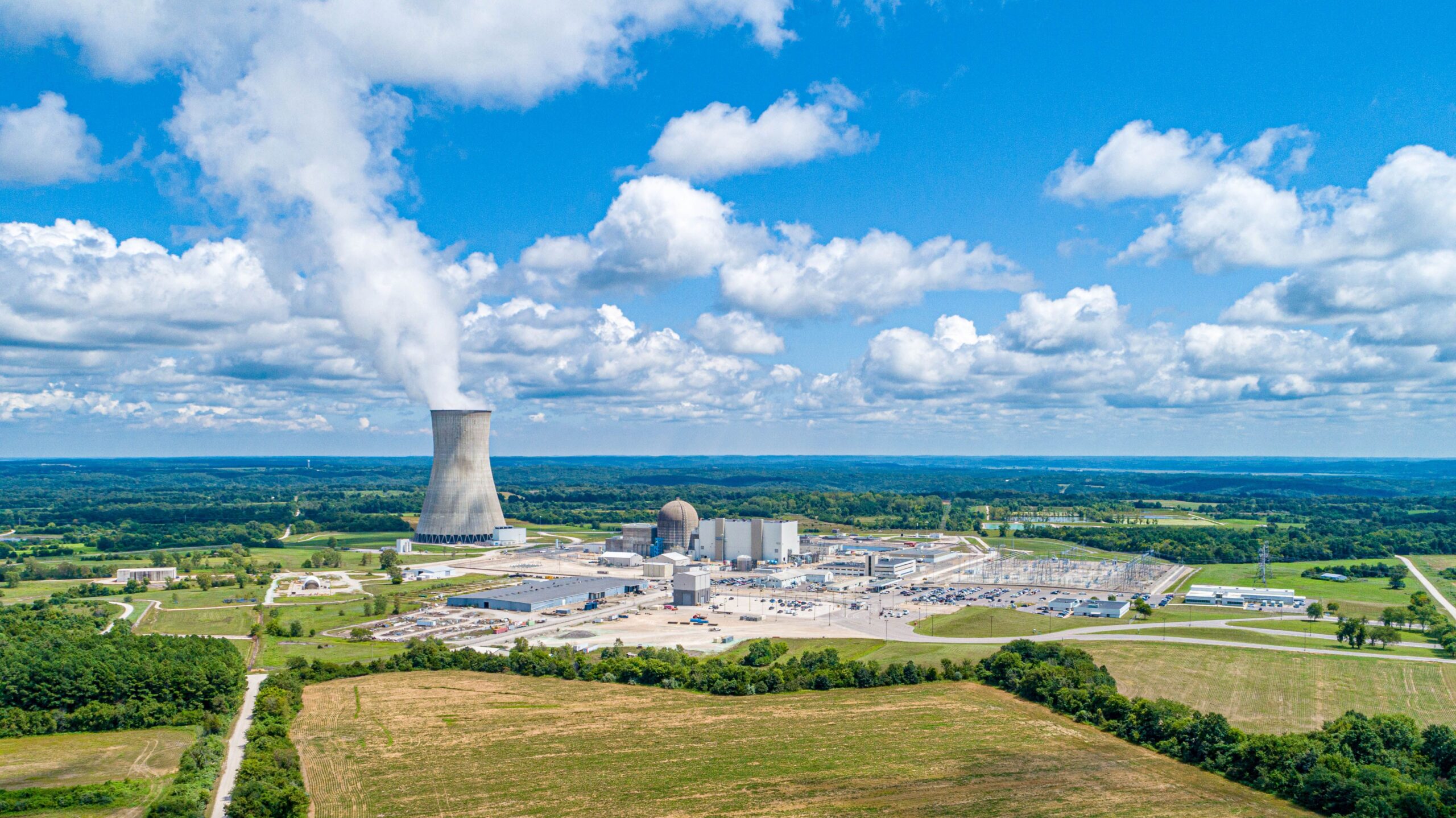 Planta nuclear con torre de enfriamiento bajo cielo azul